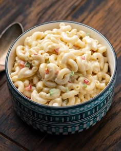 a bowl filled with macaroni and cheese on top of a wooden table