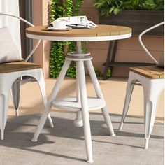 a table with two chairs next to it and a potted plant in the background