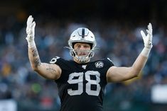 a close up of a football player holding his hands in the air