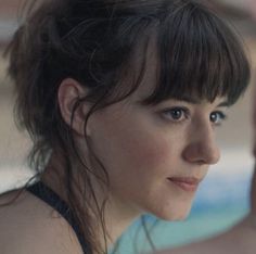 a close up of a person wearing a black top and holding something in her hand