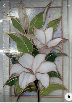 a stained glass window with white flowers and green leaves in the center, on a silver background