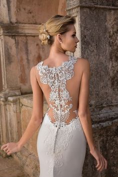 a woman in a wedding dress with an open back and lace detailing on the top