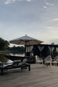 an umbrella and some chairs on a wooden deck