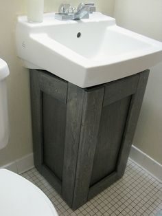 a white toilet sitting next to a sink in a bathroom on top of a tiled floor