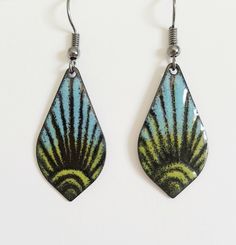 "These copper enameled earrings are done in shades of saphire blue and chartreuse over black. A sun burst pattern is etched into the enamel before firing. They are a 1 \" long drop shaped copper. These earrings are custom made with each order and I hand fired with a torch. Because they are hand made each time the end result can vary slightly. These earrings can be custom made to order - just send me an email with the colors you would like and what kind or earwire - copper, gunmetal or surgical s Multicolor Enamel Jewelry With Ear Wire, Retro Blue Drop Earrings Jewelry, Retro Green Enamel Jewelry, Artistic Black Enamel Jewelry, Green Teardrop Enamel Jewelry, Nickel-free Enamel Retro Jewelry, Blue And Chartreuse, Beachy Earrings, Sun Burst