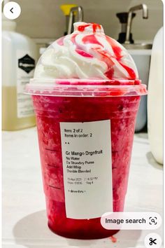 a cup filled with whipped cream and red liquid