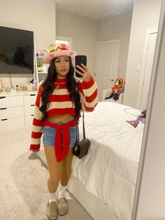 a woman taking a selfie in her bedroom wearing a red and white striped sweater