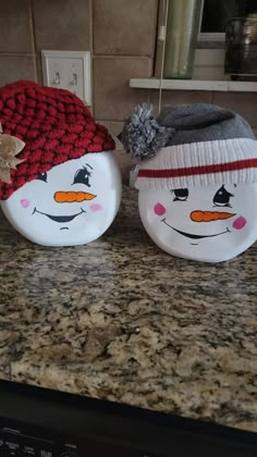 two ceramic snowmen sitting on top of a counter