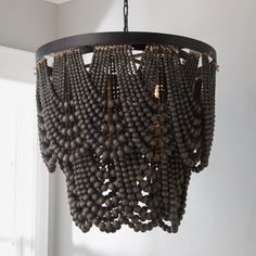 a chandelier made out of wooden beads hanging from a ceiling in a room