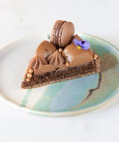 a piece of chocolate cake on a blue and white plate with a flower in the middle