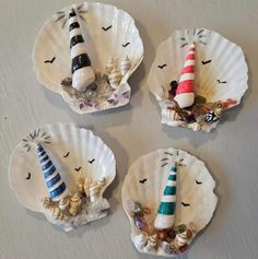 three small seashells with lighthouse decorations on them