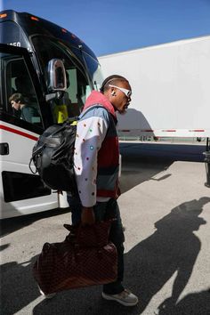 a man with a backpack walking towards a bus