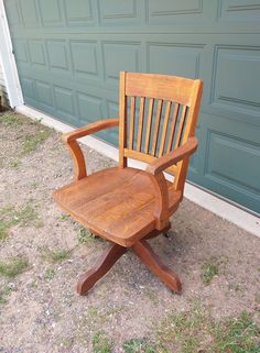 a wooden chair sitting in front of a garage door