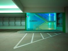 an empty parking garage with blue and green lighting