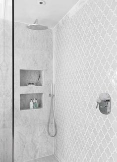 a bathroom with a shower and shelves on the wall