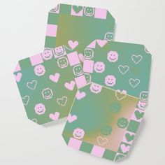 three coasters with hearts and squares on them, one is green and the other is pink