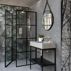 a bathroom with a sink, mirror and walk in shower next to a tiled wall