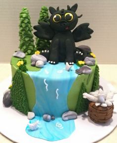 a cake decorated with an image of a black cat sitting on top of a waterfall