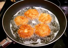 fried food being cooked in a frying pan on the stove top with water and oil