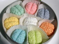 there are many different colored brain shaped treats in the tin