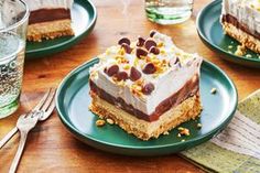 three plates with desserts on them sitting on a table next to glasses and silverware