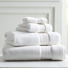 a stack of white towels sitting on top of a table