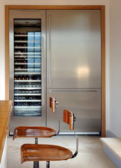 a stainless steel refrigerator and wine rack in a kitchen