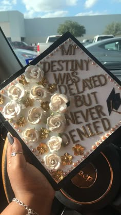 someone is holding up a graduation cap with flowers on it