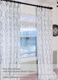 the curtains in this room are white and have an intricate pattern on them, while the clock is mounted to the wall