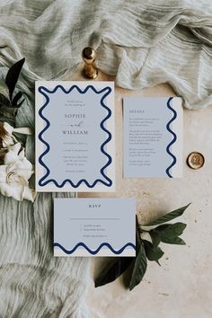 the wedding stationery is laid out on top of a table with flowers and greenery