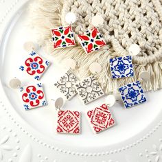 several colorful tile pieces are on a white plate next to a crochet doily