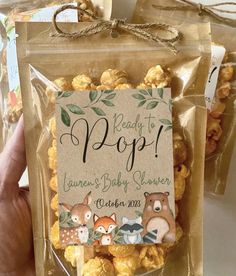 someone holding up a bag of popcorn with woodland animals on it and the label reads ready to pop