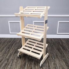 a wooden shelf with wheels on the floor