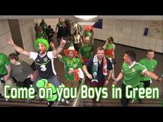 a group of people in green shirts and hats on some stairs with the words come on you boys in green