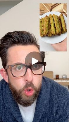 a man with glasses is looking at the camera and has food in front of him