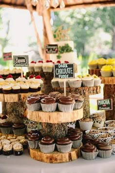 a table topped with lots of cupcakes covered in frosting and toppings