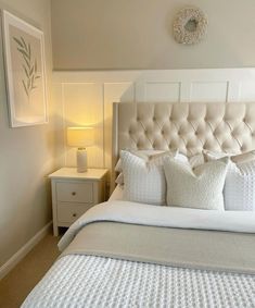 a bed with white sheets and pillows in a bedroom