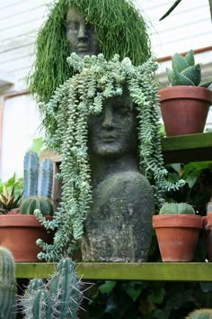 there is a statue surrounded by potted plants