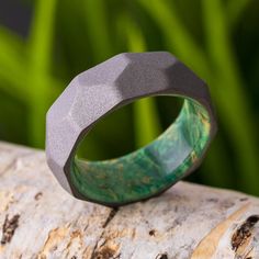 a green ring sitting on top of a piece of wood