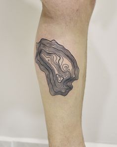 a man's leg with a black and white tattoo design on his left calf