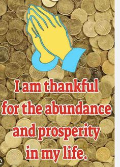 i am grateful for the abundance and prosperity in my life with hand on pile of coins