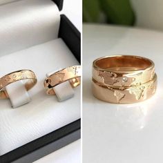 two gold rings sitting on top of a white table next to a box filled with jewelry