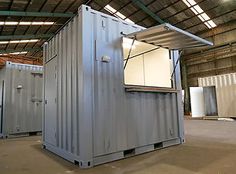 two large metal containers in a warehouse with one open door and the other closed up