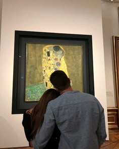 a man and woman looking at an art work