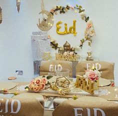 the table is decorated with gold letters and flowers on it, along with other decorations