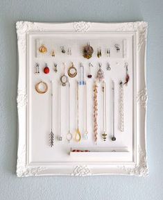 a white frame with jewelry hanging on it and the words jewelry storage displayed above it