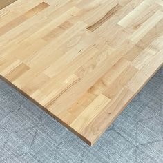 a wooden table top sitting on top of a carpeted floor