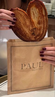 a woman holding a bag with some bread in it