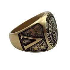 a gold signet ring with an emblem on it