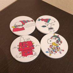 four snoopy christmas coasters sitting on top of a table